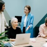 Arbeitgeberbewertungen: Deine Stimme zählt arbeitgeberbewertungen gruppe von personen sitzend und stehend und laptop auf dem tisch @ cottonbro pexels.com