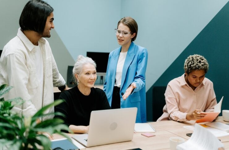 arbeitgeberbewertungen gruppe von personen sitzend und stehend und laptop auf dem tisch @ cottonbro pexels.com