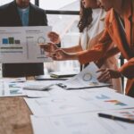 Pivot im Startup Pivot Startup Gründer Team um einen Tisch mit Tabellen und uNterlagen bei der Neuausrichtung des Unternehmens!