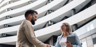 Angel-Investor und Gründerin in einer Eingangshalle eines Gebäudes beim Händeschütteln!