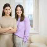 Ovy: Hormonfreie Zyklus-App mit medizinischer Zertifizierung Zyklus App von Ovy Gründerinnen 2 Lina Wüller (links) Eval Leonhardt (rechts) vor einer Wand mit Fentser und eimem Sessel @ Ovy GmbH