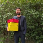 Überraschung garantiert: Einblicke hinter die Kulissen snackonomy Gründer snackboxen gründer can berkay tok mit den boxen in der hand stehend