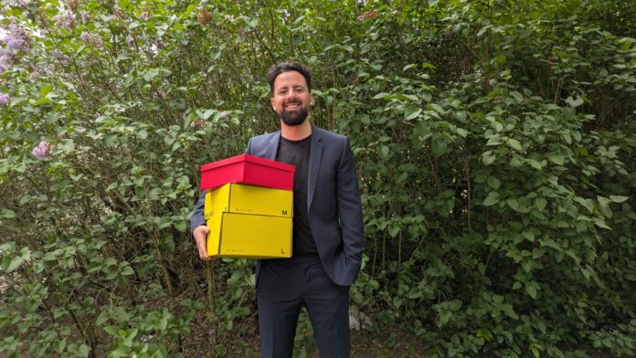 snackonomy Gründer snackboxen gründer can berkay tok mit den boxen in der hand stehend