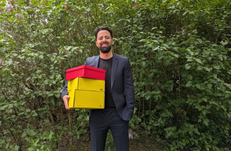 snackonomy Gründer snackboxen gründer can berkay tok mit den boxen in der hand stehend