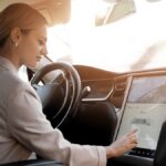 Das Auto der Zukunft – Made in Vietnam? Vietnam KI und die Zukunft der Automobilindustrie Frau im Auto bedient auto mit touchscreen