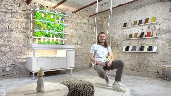 LIROGA indoor pflanzen Gründer Stefan Kuhnert vor Indoor-Garten im hängestuhl sitzend