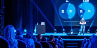 Startup Events Herbst 2025: Top Gründer-Termine in Europa Publikum auf einem Event auf der Bühne ist ein sPSrecher blaue Beleuchtung