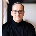 Warum scheitern so viele gute Ideen an der Umsetzung? Valuedesk plattform unternehmen Torsten Bendlin @ Valuedesk Portrait bild mit schwarzem oberteil und brille auf