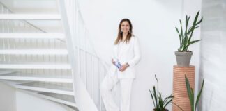 Dopper Flasche nachfüllen gründerin mit einer dopper flasche in der hand in weiss stehend vor der treppe Virginia Yanquilevich @ amaury miller