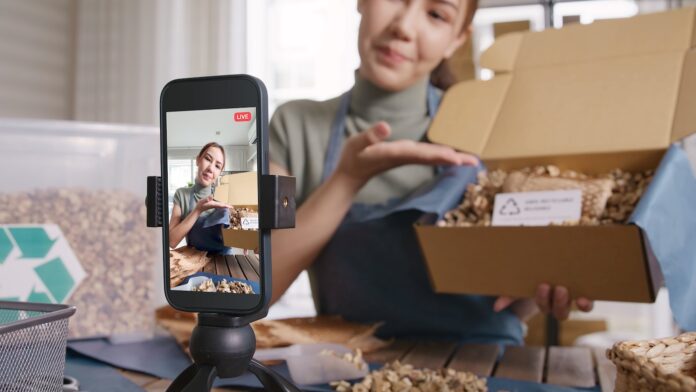TikTok 2025 social media marketing Junge Frau nimmt macht ein Livestream auzf TikTok und zeigt Ihre Produkte