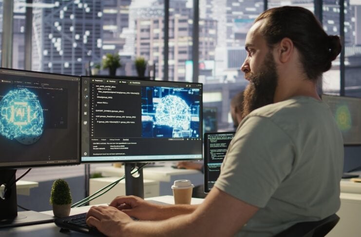 ki tools chatgpt startups einsatz Startup Mitarbeiter der am Computer mit einer Künstlichen Intelligenz arbeitetr