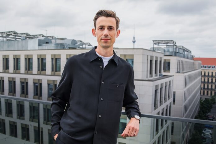 project-a-ventures-philipp-werner-gruender-tipps–Portraits–Philipp–PressPortrait Philipp Werner in Berlin auf einer Dachterasse mit einigen Hochhäusern im Hintergrund