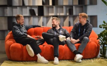 Wie verändert eine einzige Idee die Art, wie wir Genuss heute verstehen? RumX – Die Rum App für Rum Bewertungen.Team Bild sitzend auf einem roten sofa