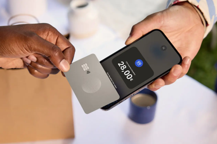 Eine Person hält eine silberne Kreditkarte auf ein Smartphone. Das Display zeigt einen Einkaufsbetrag.
Copyright: PayPal