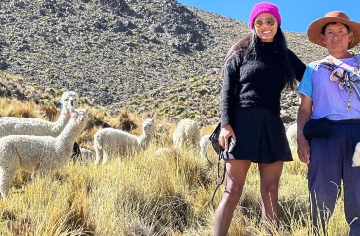 Alpaca MGO: Alpakafaser und Mode aus Peru Gründerin Maggie Garcia mit Alpakas im Hintergrund