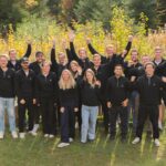 Aampere Finanzierung: Startup sammelt 4,2 Millionen Euro für E-Auto-Plattform ein Aampere Finanzierung Das Aampere Team steht nach der erfolgreichen 4,2 Mio. Euro Finanzierung auf einer Wiese vor einer Hecke.