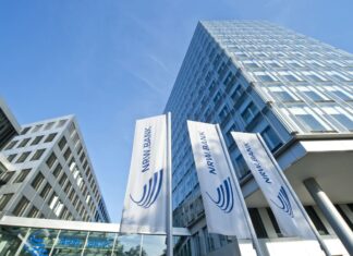amber entwickelt KI für Unternehmenswissen und erhält sieben Millionen Euro für Wachstum. Drei Millionen Euro investiert die NRW.BANK in das Start-up. NRW.BANK Gebäude in Düsseldorf mit Fahnen und blick nach oben entlang des Gebäudes!