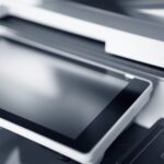 Wo bekommt man günstige Toner für den Laserdrucker? Der Einkaufs-Check für kleine Teams Günstige Toner für den Laserdrucker: Der Einkaufs-Check. Nahaufnahme eines modernen Druckers mit Touchscreen in einem professionellen Büro