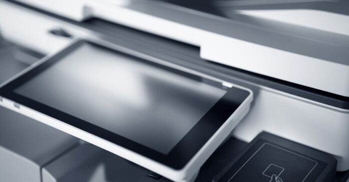 Günstige Toner für den Laserdrucker: Der Einkaufs-Check. Nahaufnahme eines modernen Druckers mit Touchscreen in einem professionellen Büro