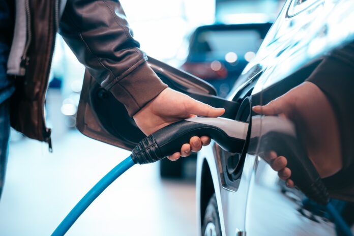 ETERNALYTE 24M Battery Closes up Human hand is holding Electric Car Charging connect to Electric car